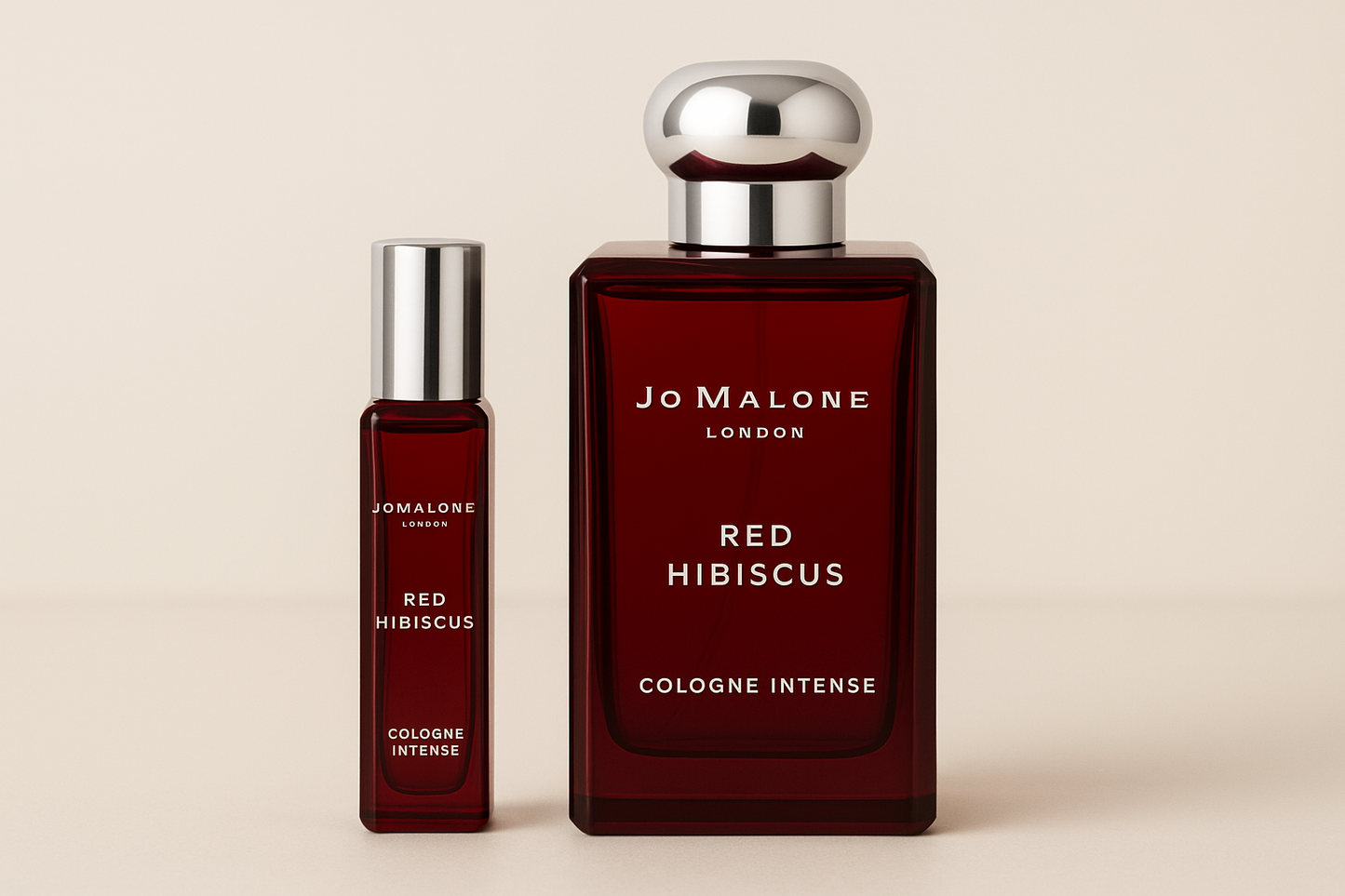 Mostră de 12 ml Jo Malone Red Hibiscus Cologne Intense, așezată lângă sticla de parfum de 100 ml Jo Malone Red Hibiscus Cologne Intense, care are scris alb pe sticla roșu închis.